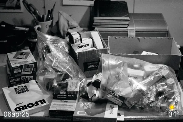 Black and white film photo of a bunch of film rolls