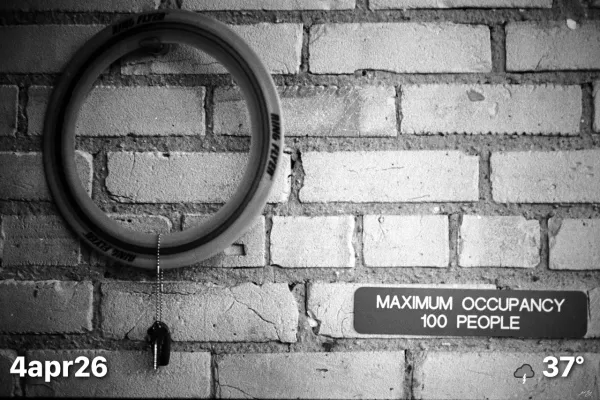 Key hanging on wall next to maximum occupancy sign