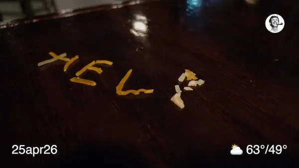 The word Help written in pieces of shredded cheese